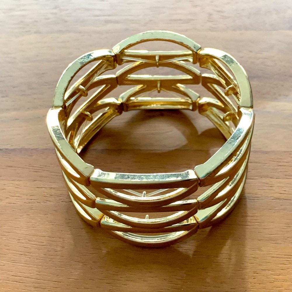 UEC Costume gold tone bracelet. 6 panels stretch on clear elastic cord. Light.